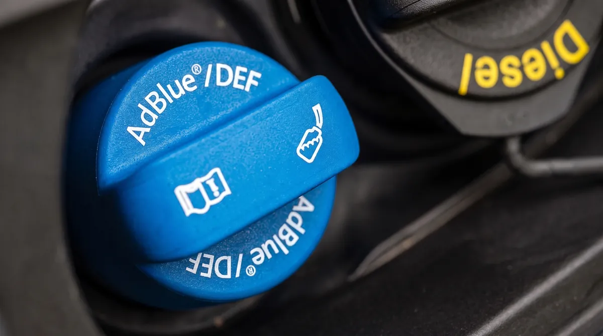 Blue AdBlue/DEF filler cap next to the diesel filler